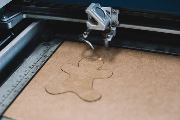 Laser cutter tracing a form on cardboard in the FabLab